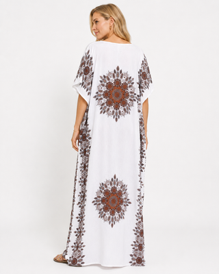 White kaftan dress with intricate brown and red patterns on the sleeves and sides