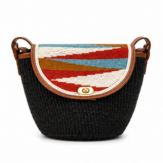 The image shows a stylish handbag characterized by its unique design. The bag features a rounded shape with a woven black body. Its flap is adorned with colorful geometric patterns in hues of red, orange, and blue, complementing the overall look. The bag is finished with brown leather accents and a decorative clasp at the front.