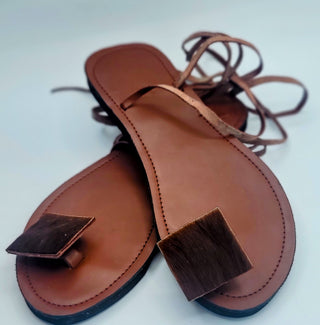 Pair of brown leather sandals with square toppers on a white background